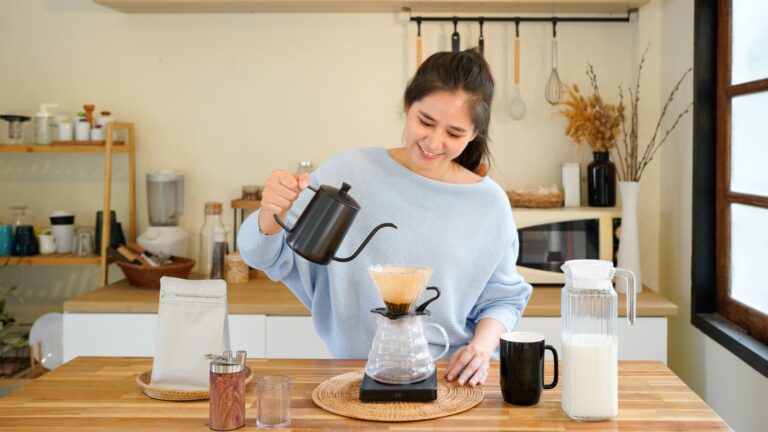 Home brewing coffee setup with a person making pour-over coffee in a bright kitchen